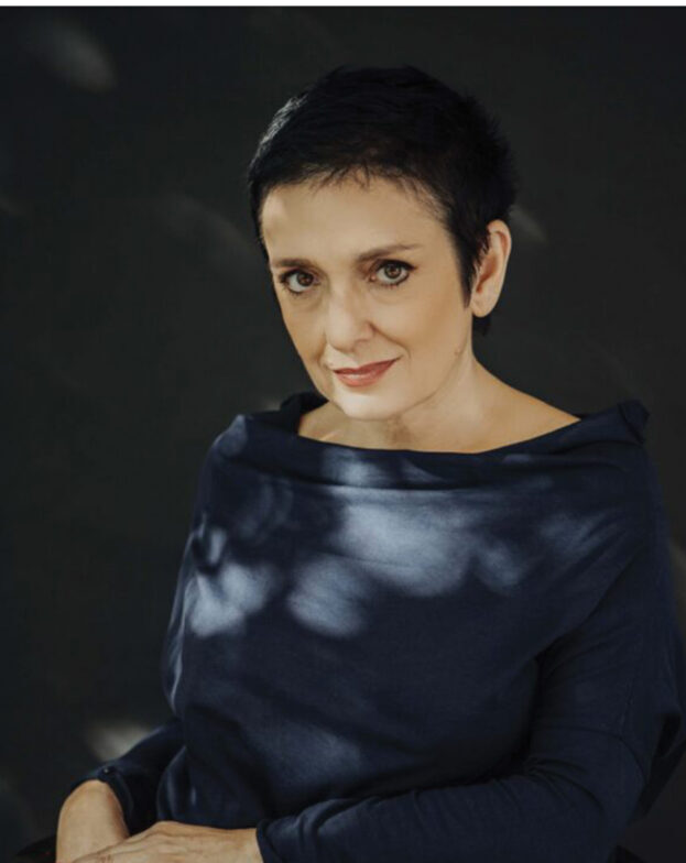 Joanna Lamparska, kobieta w krótkich czarnych włosach, ciemne tło, portret, patrzy w obiektyw