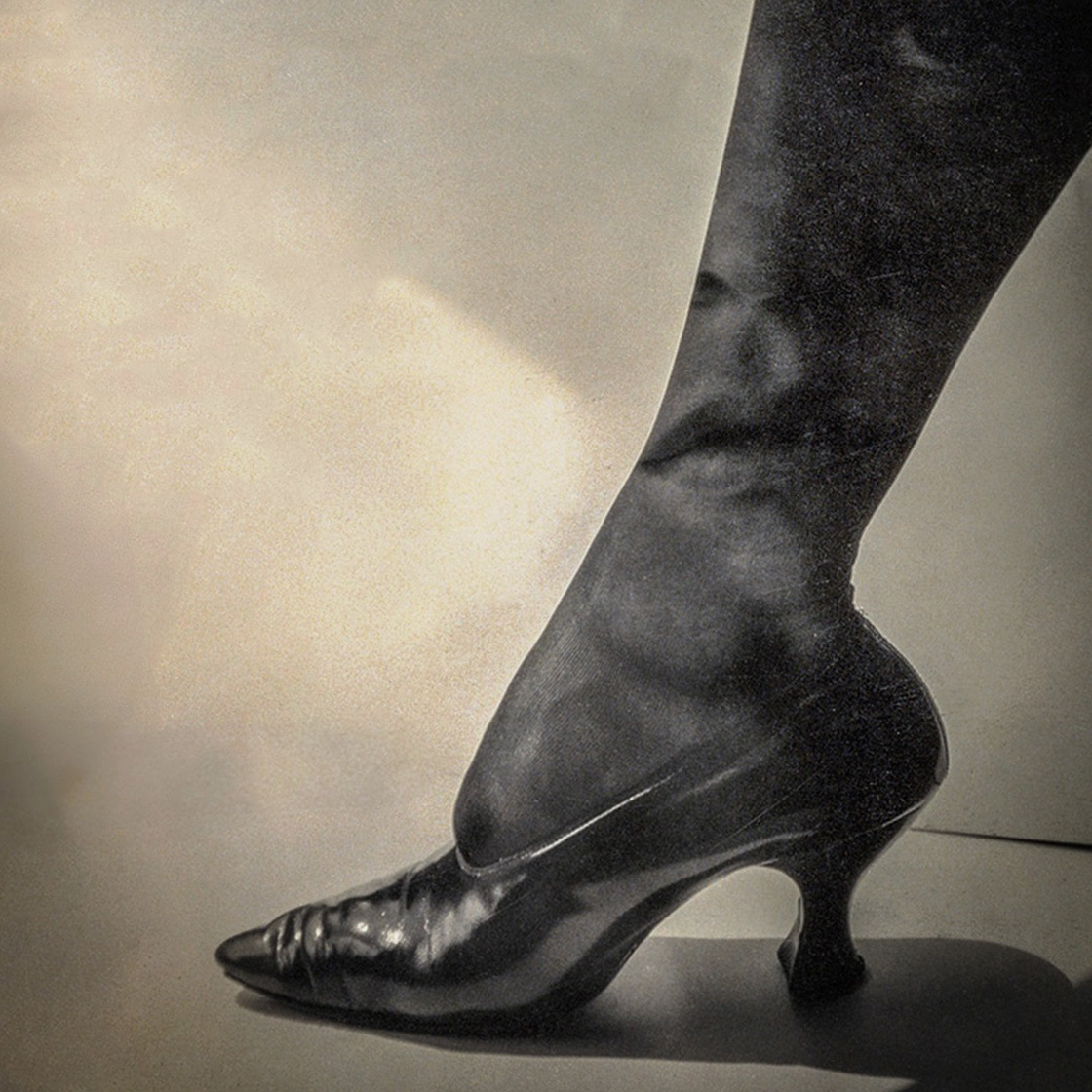 kobiecy retro bucik na nodze, w łydce odbija się twarz