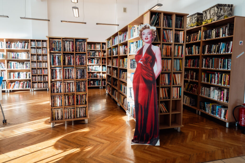przestrzeń American Corner Wrocław. Regały z książkami i postać Marlin Monroe (kartonowa sylwetka naturalnej wielkości).