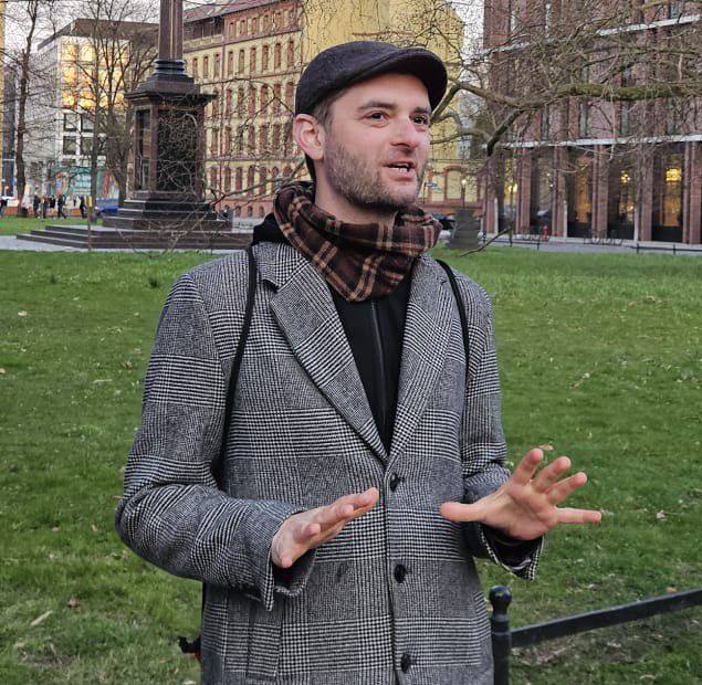 mężczyzna w kaszkiecie opowiada o mieście