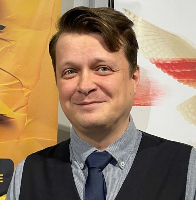 portet mężczyzny w krawacie i kamizelce, lekko się uśmiecha