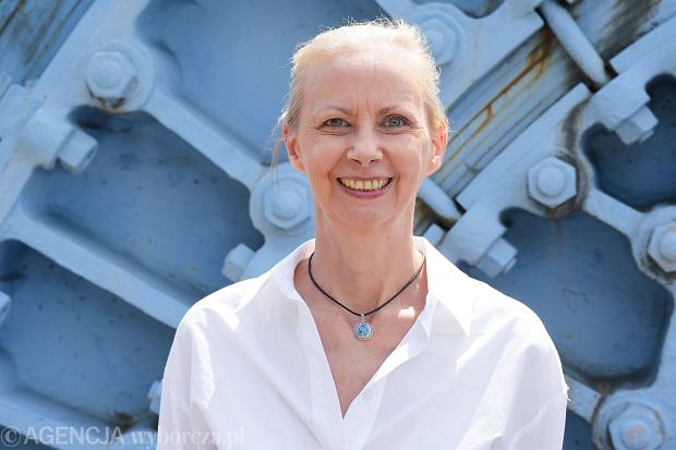 Justyna Bajda w białej koszuli na tle stalowej konstrukcji podczas wydarzenia plenerowego
